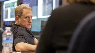 Alan Stern reviews spacecraft instructions outside New Horizons' mission control room.